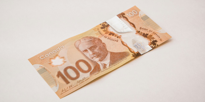 Stack of Canadian dollar banknotes showing $5, $10, $20, $50, and $100 bills