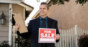 A "For Sale By Owner" sign posted in front of a residential house