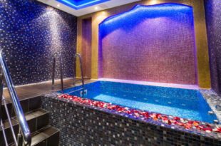 A split image showing various in-room hot tub setups, from a jetted bathroom tub to an open-concept bedroom hot tub, and a private balcony hot tub, illustrating the diverse options in room hot tub hotels.