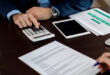 A person closely examining a document that explains what title service fees are on a closing statement.