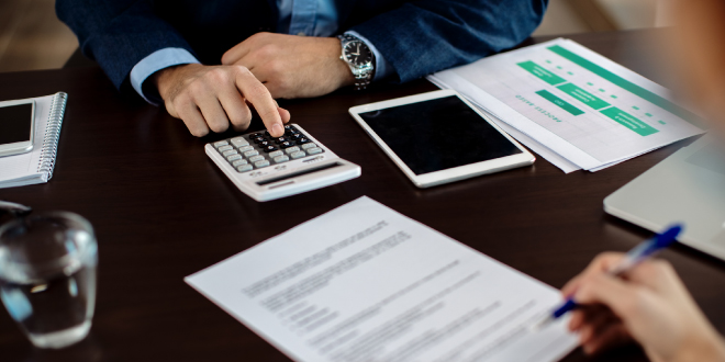 A person closely examining a document that explains what title service fees are on a closing statement.