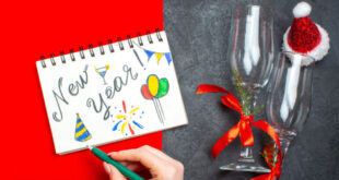 A business professional handwriting Professional New Year Wishes for Business Clients 2026 on a note card.